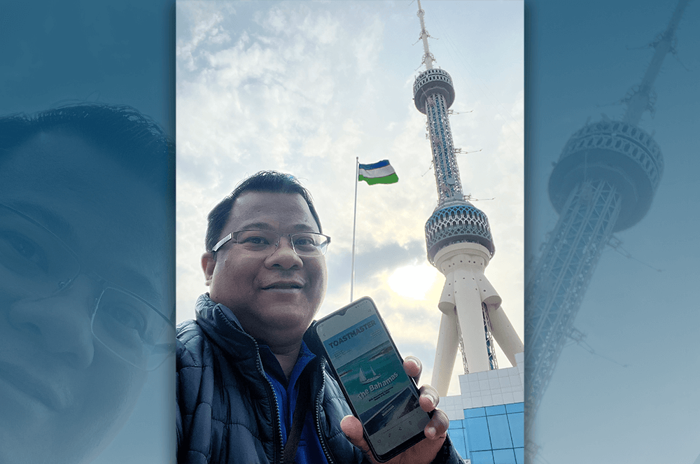 Man showing digital Toastmaster magazine on iPhone near Tashkent Television Tower
